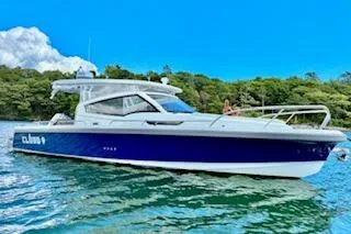 The Image of 2023 Nimbus W9 boat on water, blue and white design, lush green background. - 0