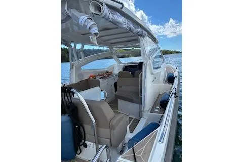 Slide: The Image of 2023 Nimbus W9 boat docked on a serene lake with lush green surroundings. - 3