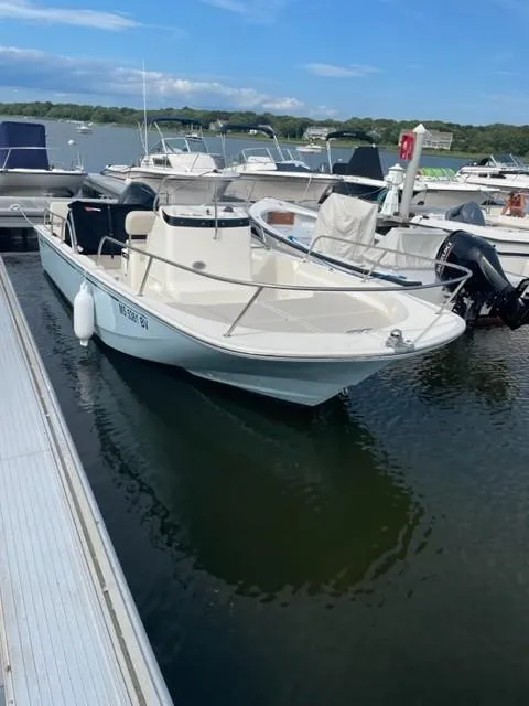 Slide: The Image of 2024 Boston Whaler 190 Montauk boat docked at marina, calm water, clear sky. - 1