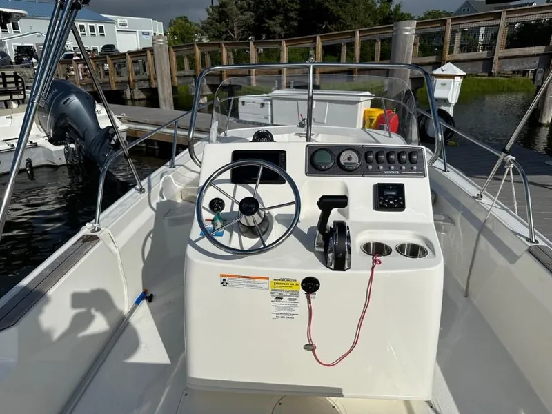 Slide: The Image of 2024 Boston Whaler 190 Montauk boat dashboard with steering wheel and controls. - 2