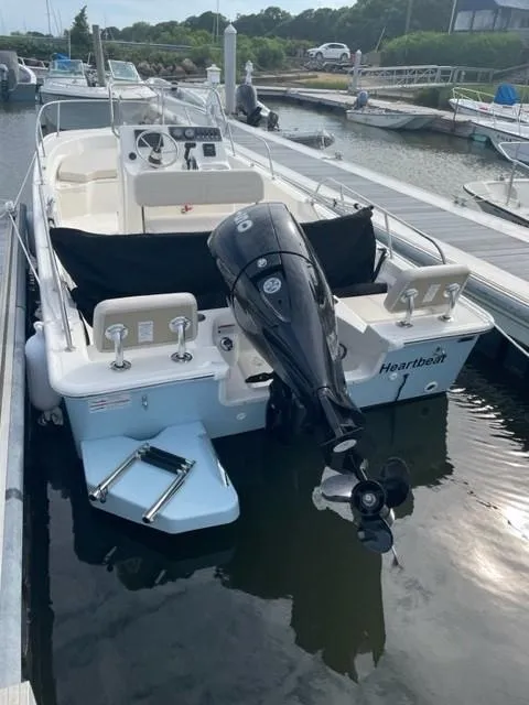 Slide: The Image of 2024 Boston Whaler 190 Montauk boat docked, rear view with motor and seating. - 4