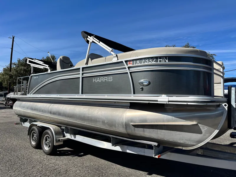 The Image of 2020 Harris FloteBote Cruiser 230 pontoon boat on a trailer, parked outdoors. - 0