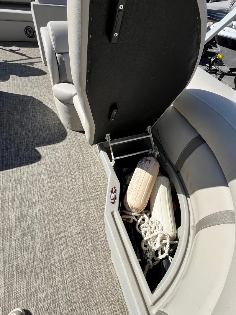 Slide: The Image of Open storage compartment in 2020 Harris FloteBote Cruiser 230, showing ropes and a fender. - 16