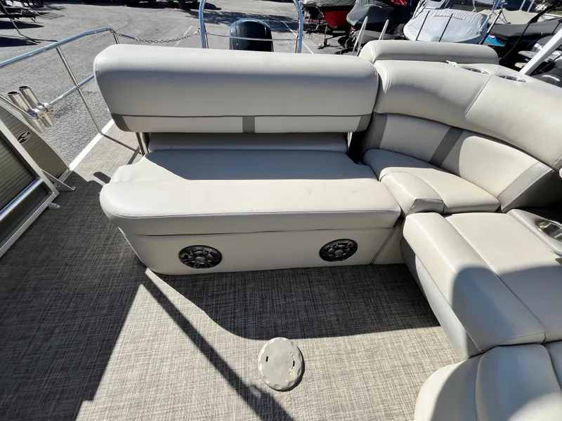 Slide: The Image of 2020 Harris FloteBote Cruiser 230 interior seating with speakers, gray upholstery, and carpeted flooring. - 17