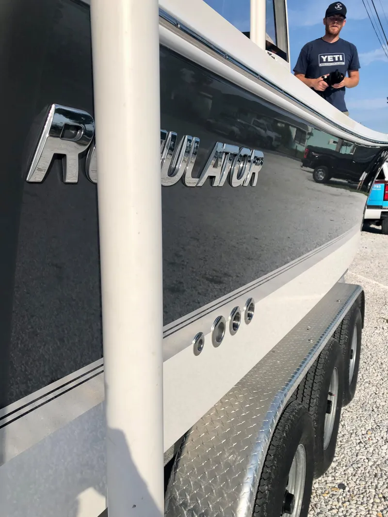 Slide: The Image of 2021 Regulator 26XO boat on trailer, side view with logo visible. - 12