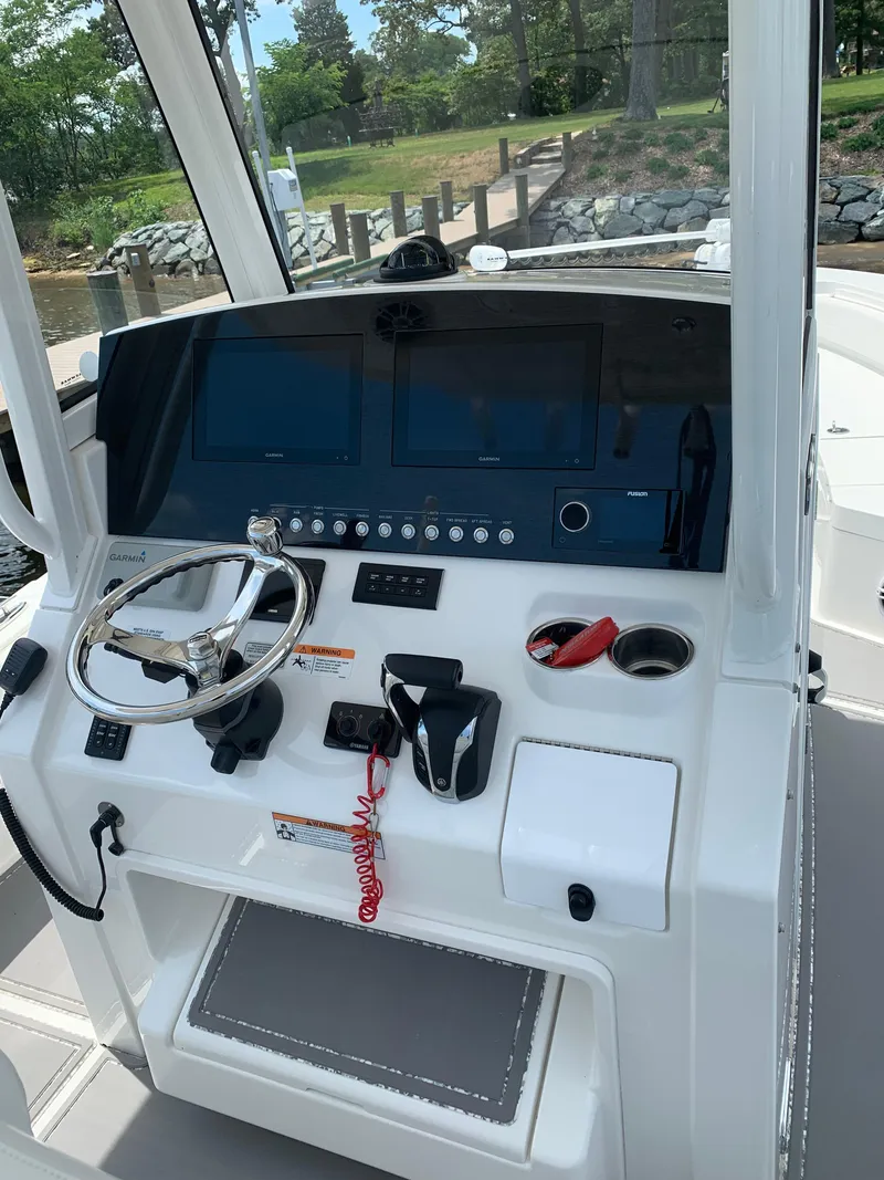 Slide: The Image of 2021 Regulator 26XO boat helm with steering wheel and control panel. - 2