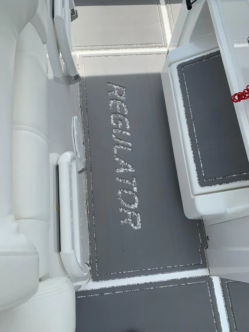 Slide: The Image of 2021 Regulator 26XO boat interior with branded flooring and white seating. - 4