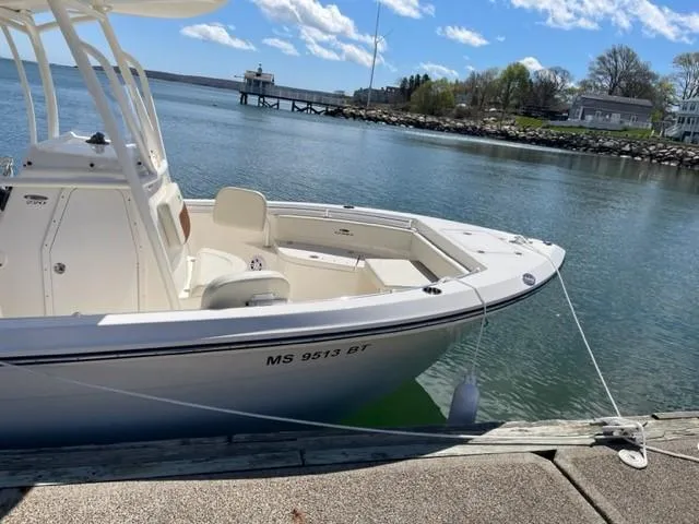 Slide: The Image of 2023 Cobia 220 CC boat docked by a scenic waterfront. - 3