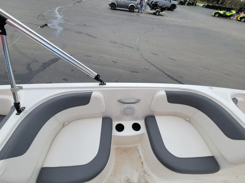 Slide: The Image of 2025 Bayliner Element E18 boat interior with gray and white seating, cup holders, and speaker. - 10
