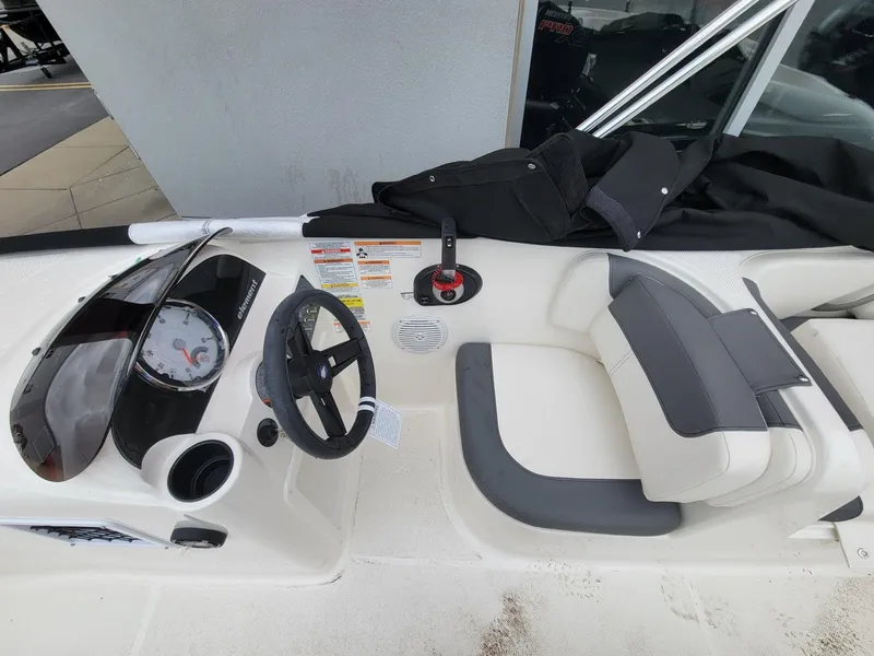 Slide: The Image of 2025 Bayliner Element E18 boat interior with steering wheel and seating area. - 16