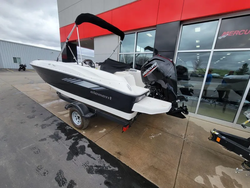 Slide: The Image of 2025 Bayliner Element E18 boat with Mercury engine on a trailer outside a dealership. - 2
