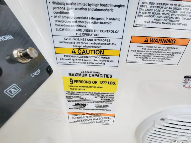Slide: The Image of Warning labels and capacity information on a 2025 Bayliner Element E18 boat. - 20