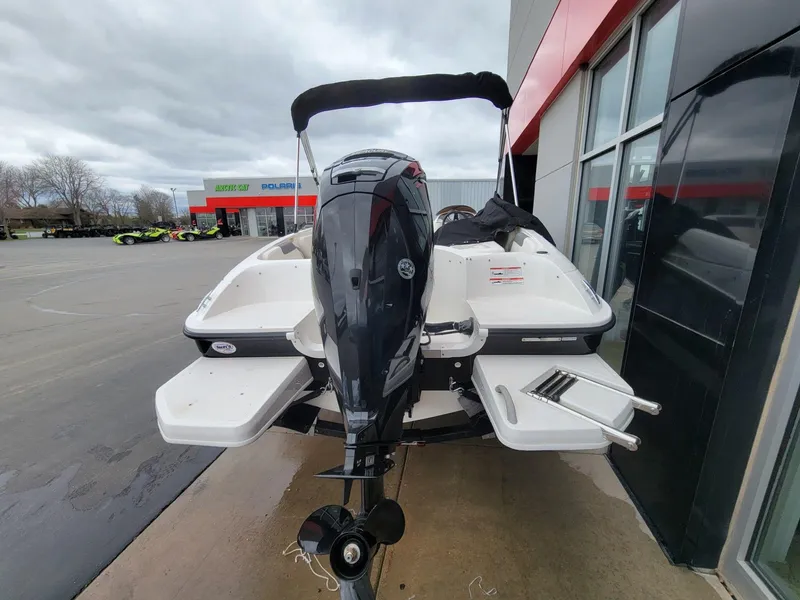 Slide: The Image of 2025 Bayliner Element E18 boat with outboard motor, parked near dealership. - 9