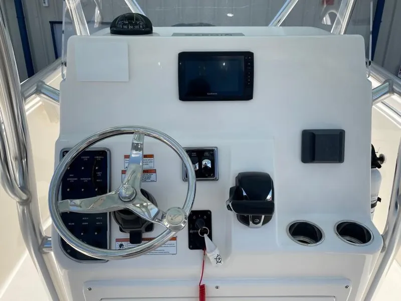 Slide: The Image of 2023 Cobia 237 CC boat dashboard with steering wheel, controls, and display screen. - 1