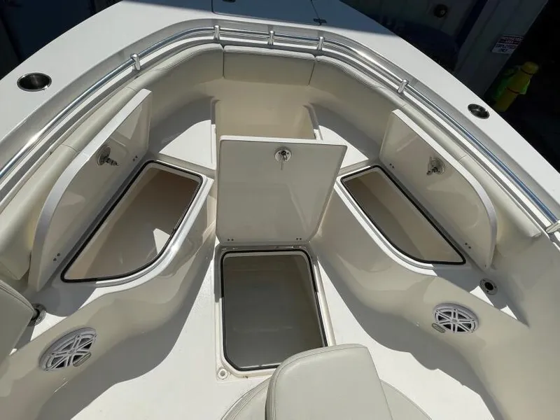 Slide: The Image of 2023 Cobia 237 CC boat interior with open storage compartments and seating area. - 3
