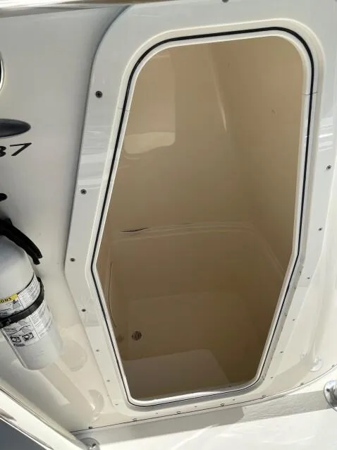 Slide: The Image of 2023 Cobia 237 CC boat storage compartment with fire extinguisher. - 4