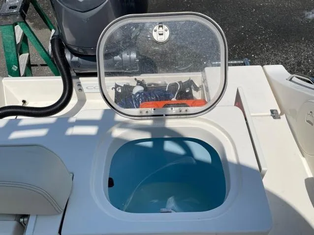 Slide: The Image of 2023 Cobia 237 CC boat livewell with open lid, showcasing interior and equipment. - 5