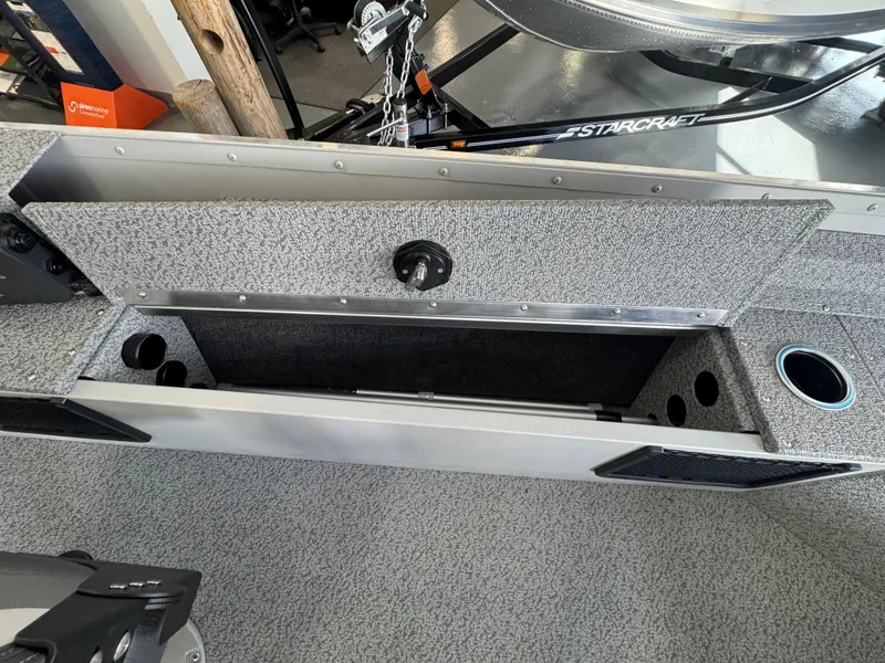 Slide: The Image of 2025 Starcraft Patriot 16 SC boat interior storage compartment with cup holders. - 9