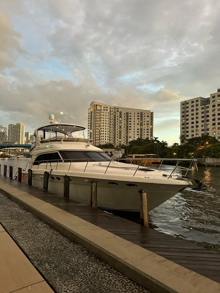 The Image of 2000 Sea Ray 480 Sedan Bridge yacht docked by urban waterfront. - 0