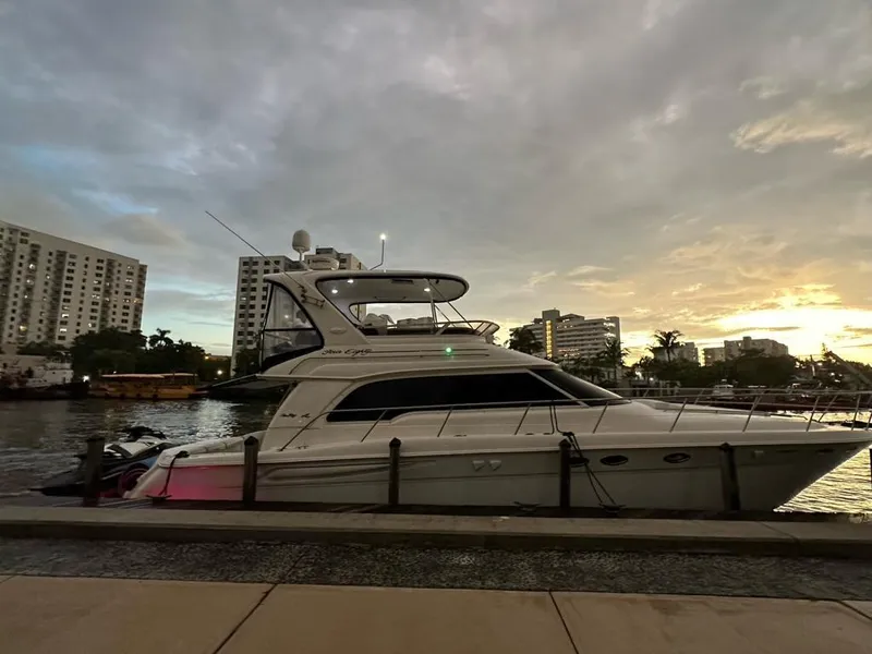 Slide: The Image of 2000 Sea Ray 480 Sedan Bridge yacht docked at sunset, cityscape in background. - 4