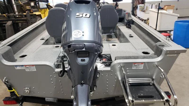 Slide: The Image of 2025 Starcraft Stealth 166SC boat with 50HP motor, rear view in a workshop. - 2