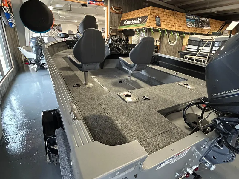 Slide: The Image of 2025 Starcraft Stealth 166SC boat interior with seating and motor in showroom. - 8