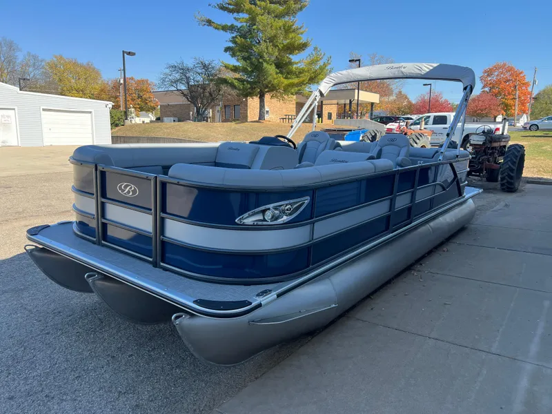 Slide: The Image of 2025 Bentley Pontoons Legacy 243 Navigator, blue and silver, parked outdoors on a sunny day. - 4