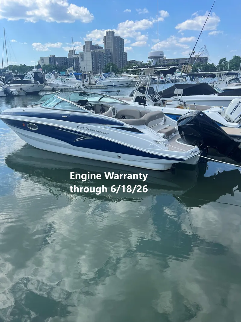 Slide: The Image of 2023 Crownline Eclipse E235 XS boat docked by the water. - 0