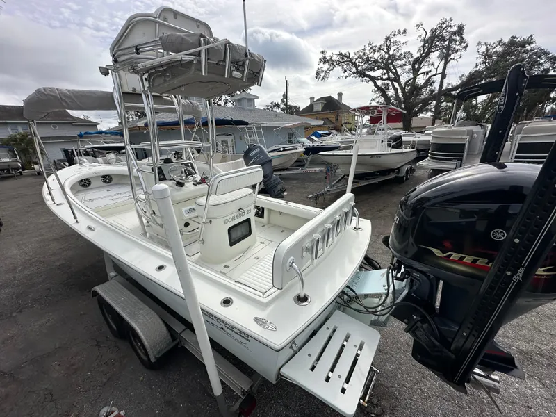 Slide: The Image of 2008 Dorado 23 Classic boat on trailer, parked in a marina with other boats. - 2