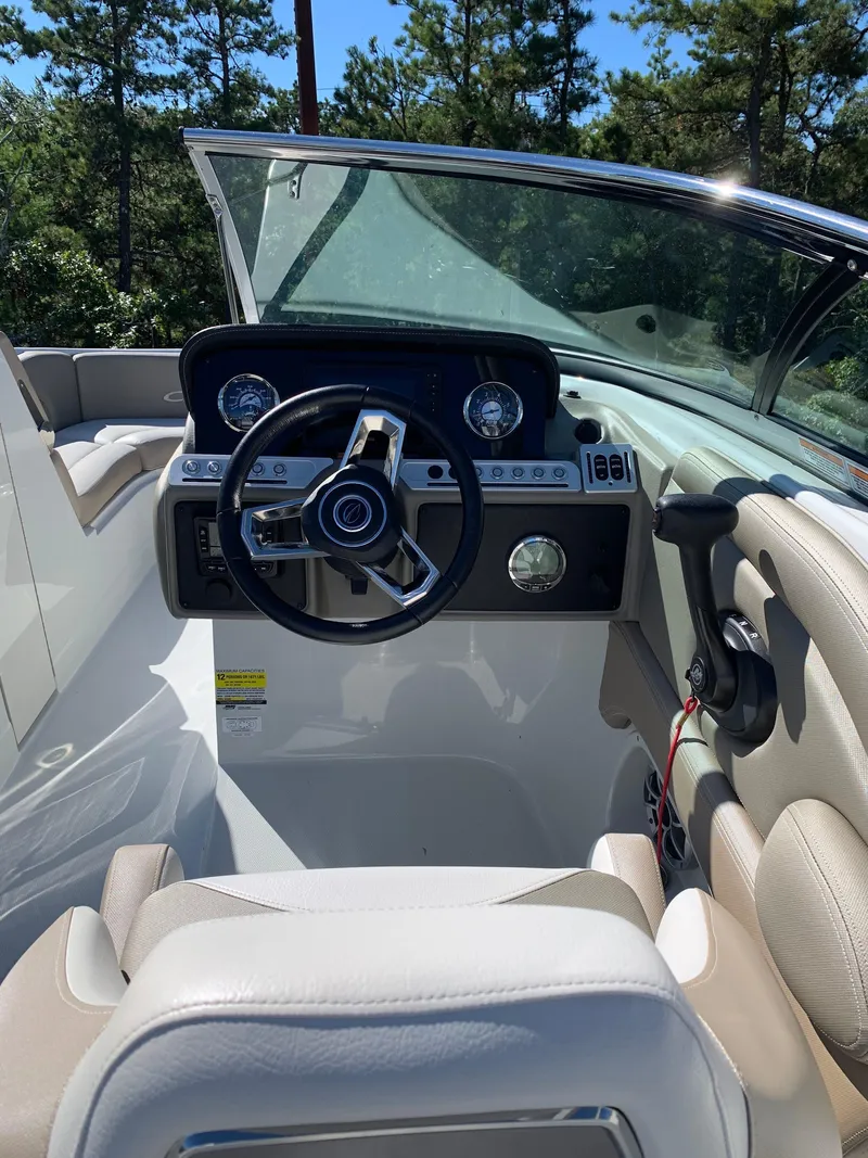 Slide: The Image of 2023 Crownline E235XS boat cockpit with steering wheel and dashboard controls. - 6