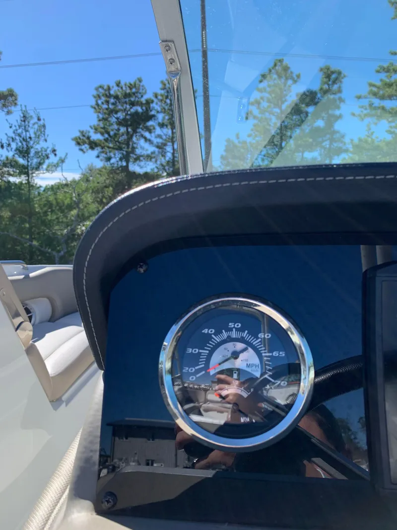 Slide: The Image of 2023 Crownline E235XS boat dashboard with speedometer, clear sky background. - 8