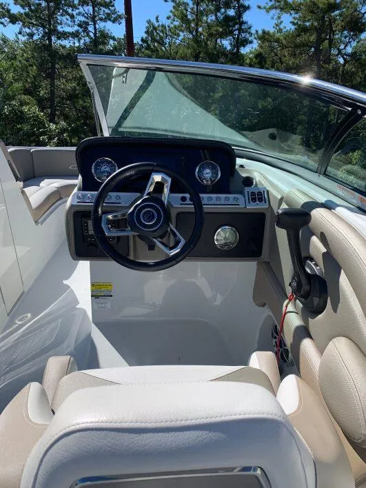Slide: The Image of 2022 Crownline E235XS boat cockpit with steering wheel and dashboard controls. - 4