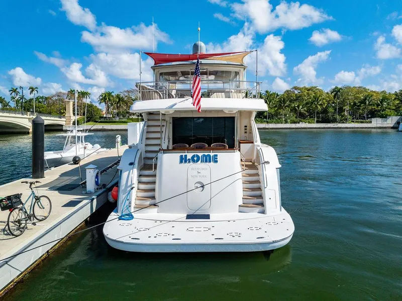 Slide: The Image of Hatteras 80 Motor Yacht 2013 docked, rear view with American flag, sunny day. - 14