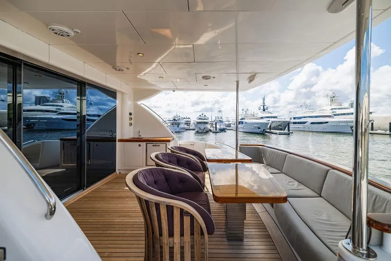 Slide: The Image of Luxurious 2013 Hatteras 80 Motor Yacht deck with elegant seating and marina view. - 19