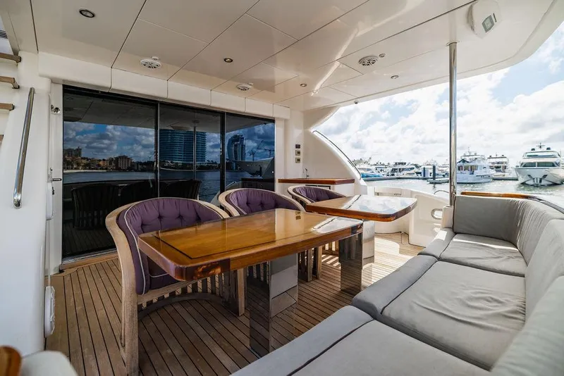 Slide: The Image of Luxurious 2013 Hatteras 80 Motor Yacht deck with elegant seating and marina view. - 20