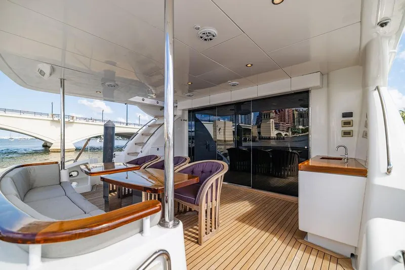 Slide: The Image of 2013 Hatteras 80 Motor Yacht deck with seating, table, and waterfront view. - 24