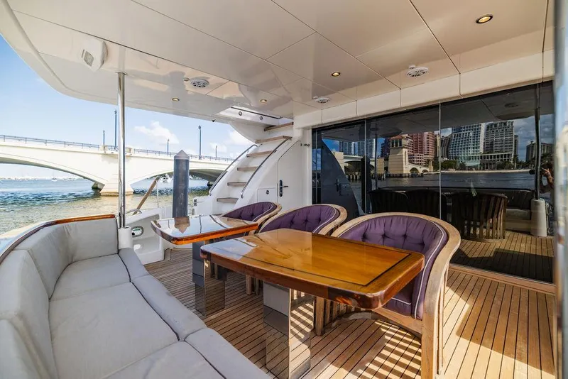 Slide: The Image of Luxury deck of 2013 Hatteras 80 Motor Yacht with elegant seating and wooden table. - 25
