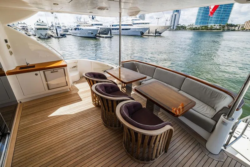 Slide: The Image of Luxurious 2013 Hatteras 80 Motor Yacht deck with elegant seating and waterfront view. - 27