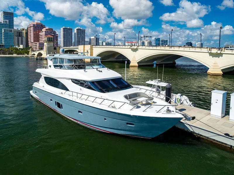 Slide: The Image of 2013 Hatteras 80 Motor Yacht docked near a bridge, city skyline in background. - 3