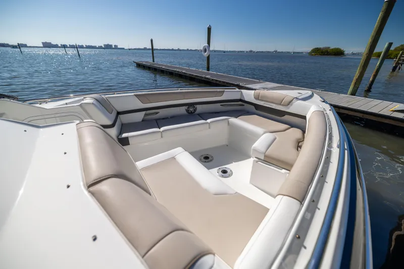 Slide: The Image of 2017 Formula 330 Crossover Bowrider at dock, featuring spacious seating and scenic water view. - 27