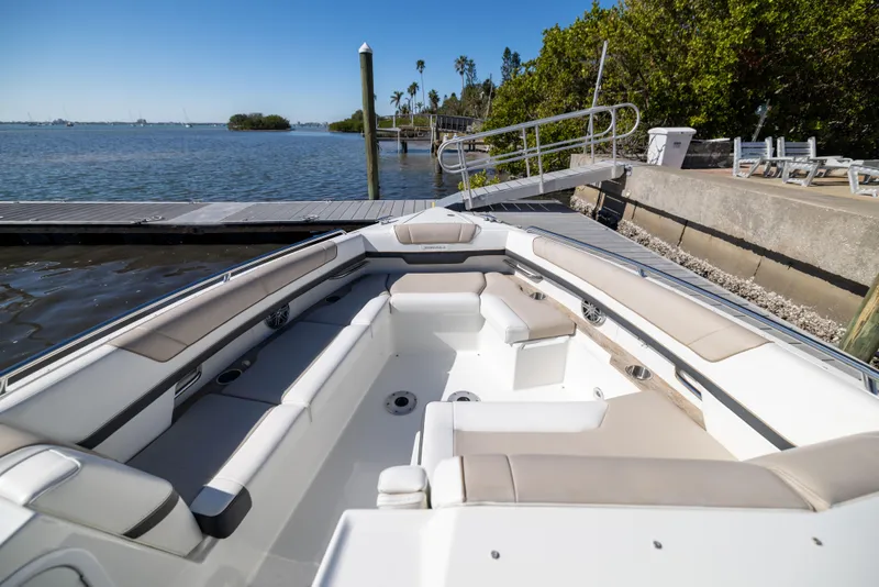 Slide: The Image of 2017 Formula 330 Crossover Bowrider at dock, featuring spacious seating and scenic waterfront view. - 29