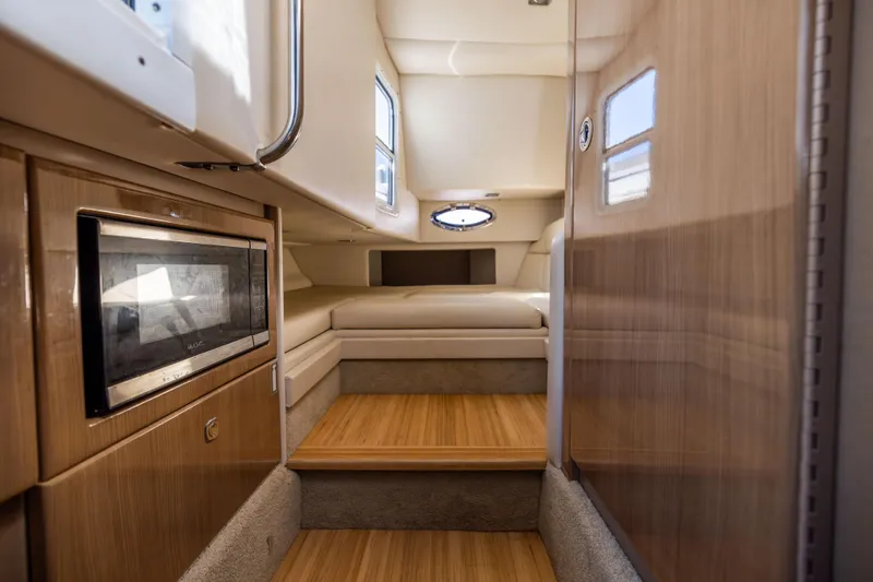 Slide: The Image of Interior of 2017 Formula 330 Crossover Bowrider, featuring wood accents and cozy seating area. - 45