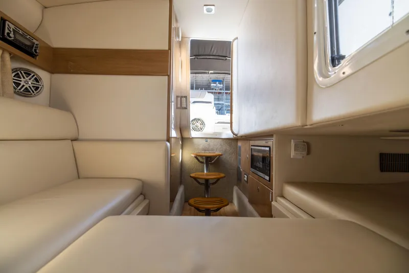 Slide: The Image of Interior of 2017 Formula 330 Crossover Bowrider, featuring seating and compact kitchen area. - 46
