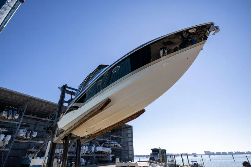 Slide: The Image of 2017 Formula 330 Crossover Bowrider boat lifted at marina, clear sky background. - 5