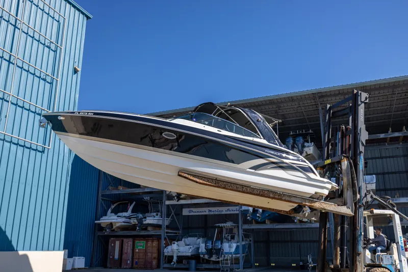 Slide: The Image of 2017 Formula 330 Crossover Bowrider on forklift at marina storage facility. - 6