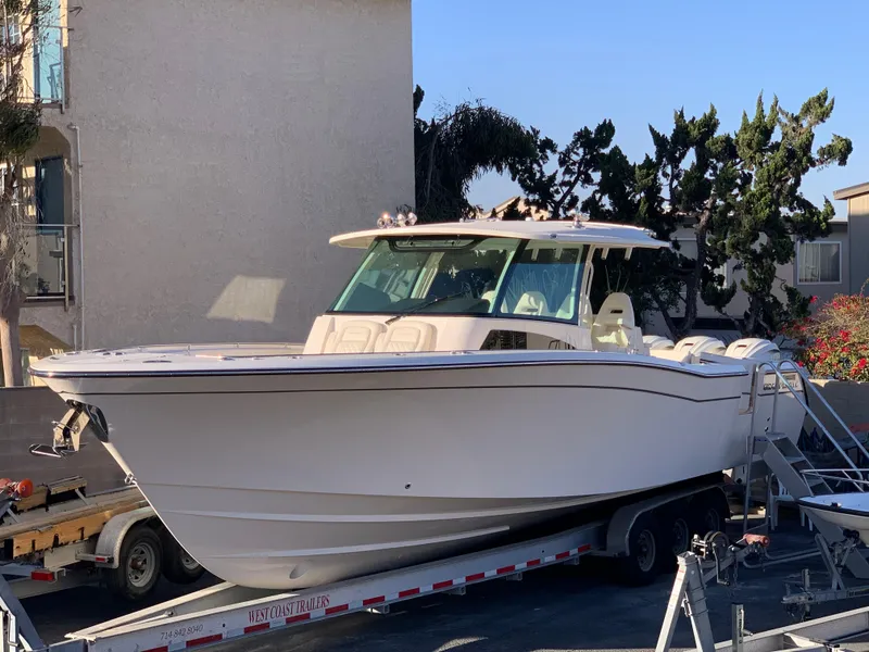 Slide: The Image of 2025 Grady-White Canyon 386 boat on trailer, parked outdoors. - 2