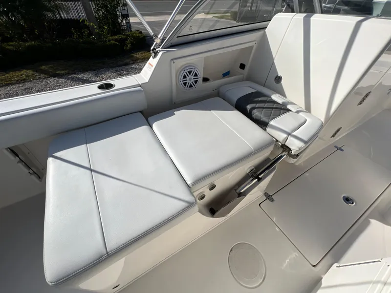 Slide: The Image of 2023 Cobia 220 Dual Console boat interior with cushioned seating and speaker. - 10