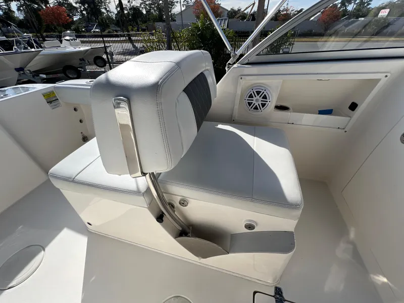 Slide: The Image of 2023 Cobia 220 Dual Console boat interior with cushioned seating and speaker. - 11
