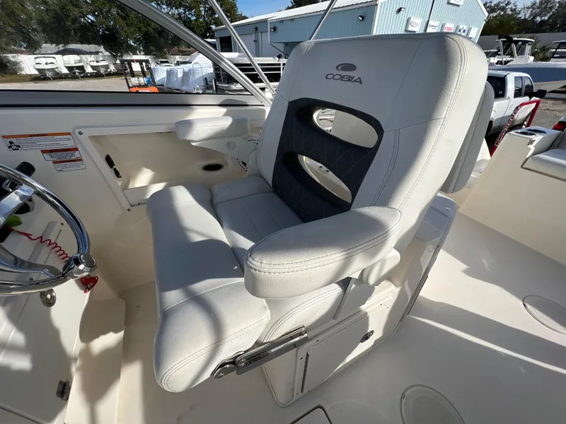 Slide: The Image of 2023 Cobia 220 Dual Console boat seat, white upholstery, outdoor setting. - 14