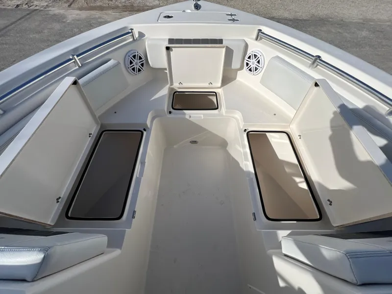Slide: The Image of 2023 Cobia 220 Dual Console boat interior with open storage compartments and seating. - 17